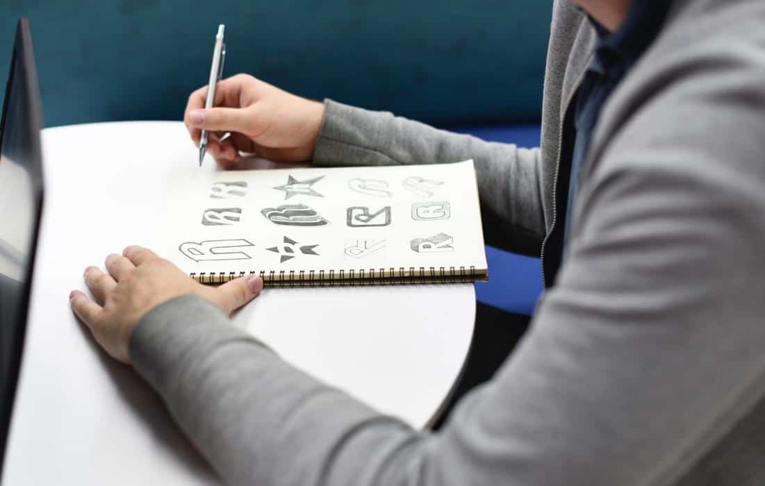 a man sketching logos for design