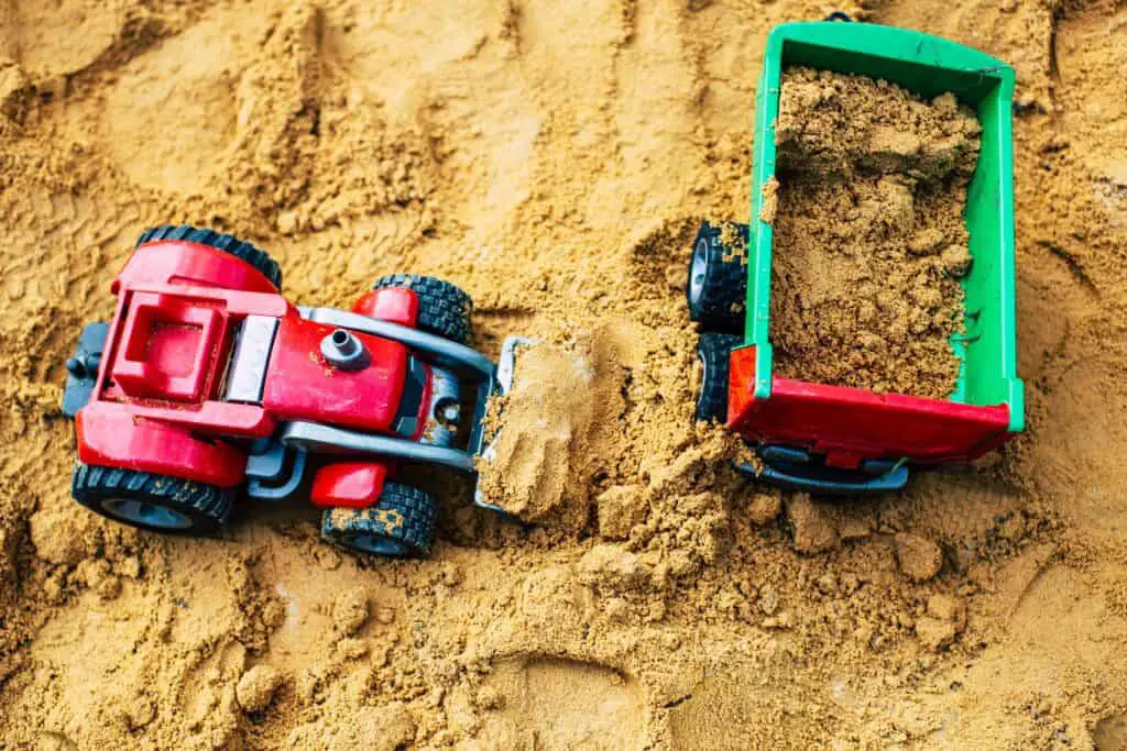 Sandbox with toy trucks for how to choose a web host