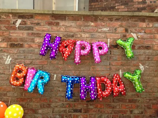 birthday campaign - birthday balloons against a brick wall