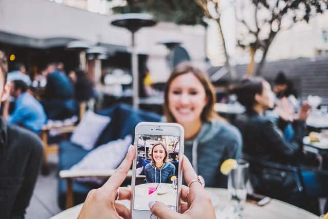 Woman recording tiktok video in a restaurant - best books about tiktok 