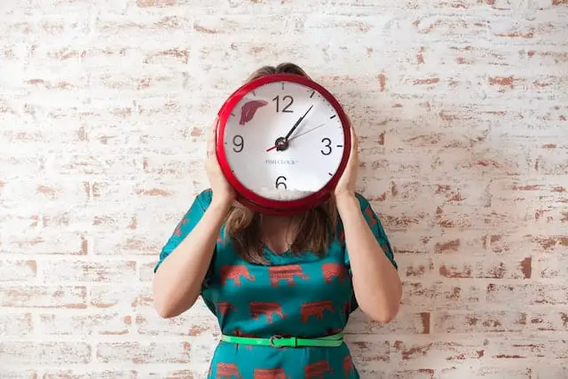 woman with clock in front of face - overcome perfectionism