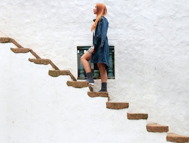 woman walking up steps with painting