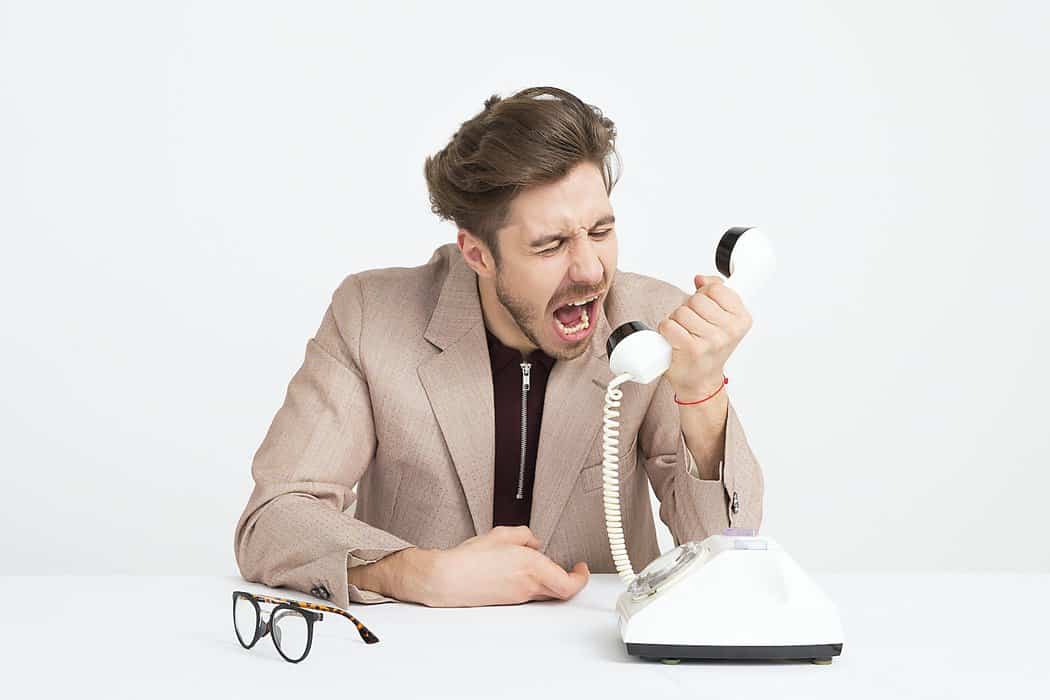 man holding telephone screaming - customer complaints