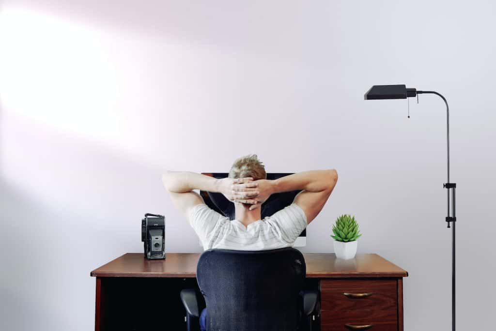man holding his head while sitting on chair near computer deskbrand monitoring tools