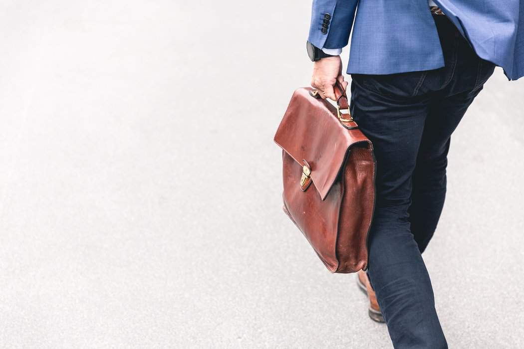 person walking holding brown leather bag - freelancer marketing tips