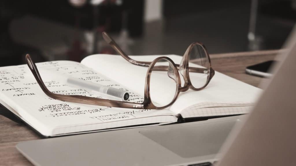 eyeglasses with gray frames on the top of notebook - black friday marketing campaign