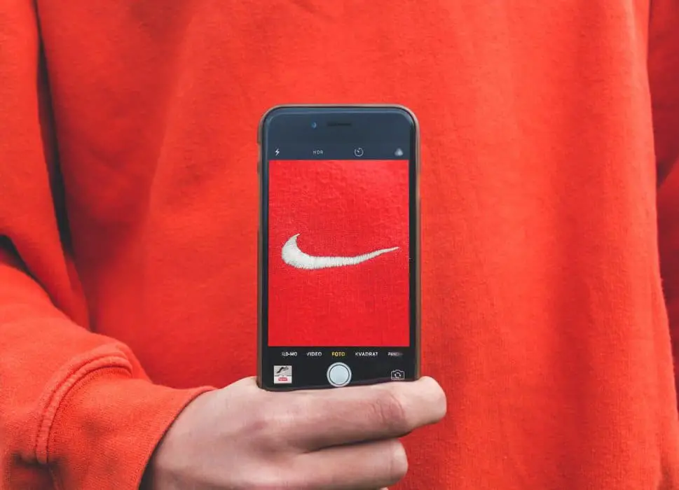 person holding iPhone taking picture on Nike label - Brand awareness campaign
