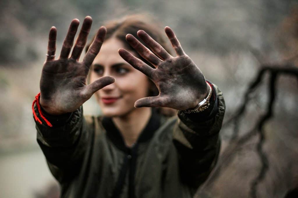 woman showing her hands with black paint - find your ideal customer