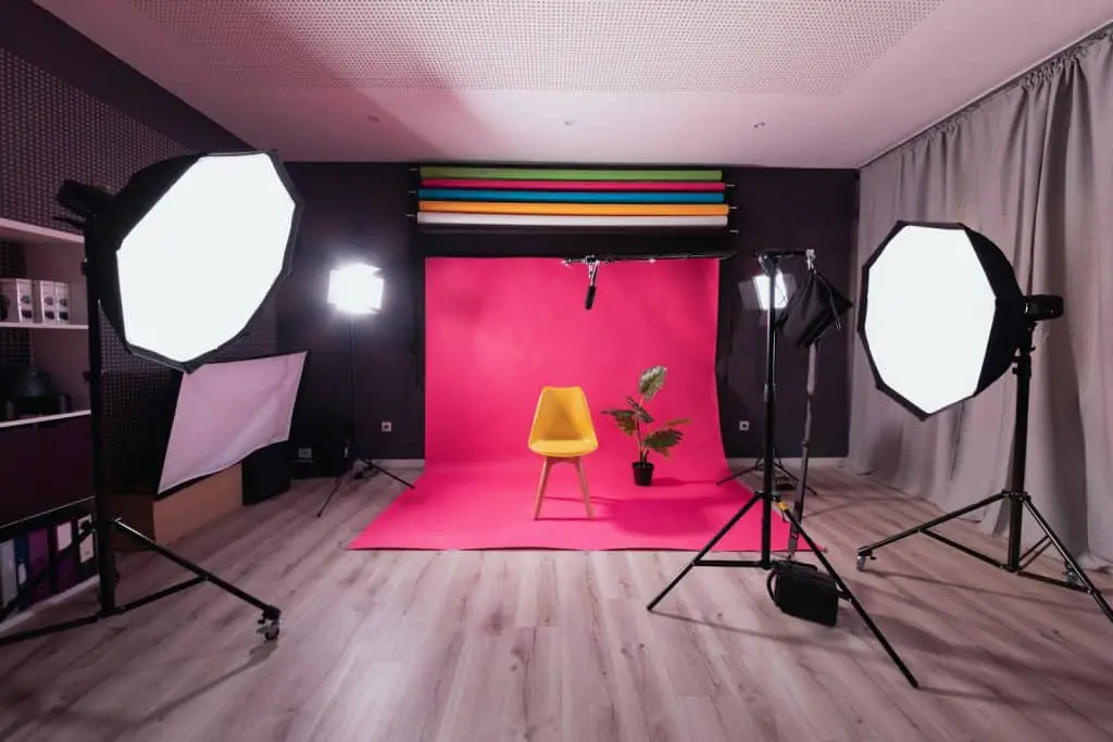a photo studio with a pink backdrop and a yellow chair - multimedia presentation