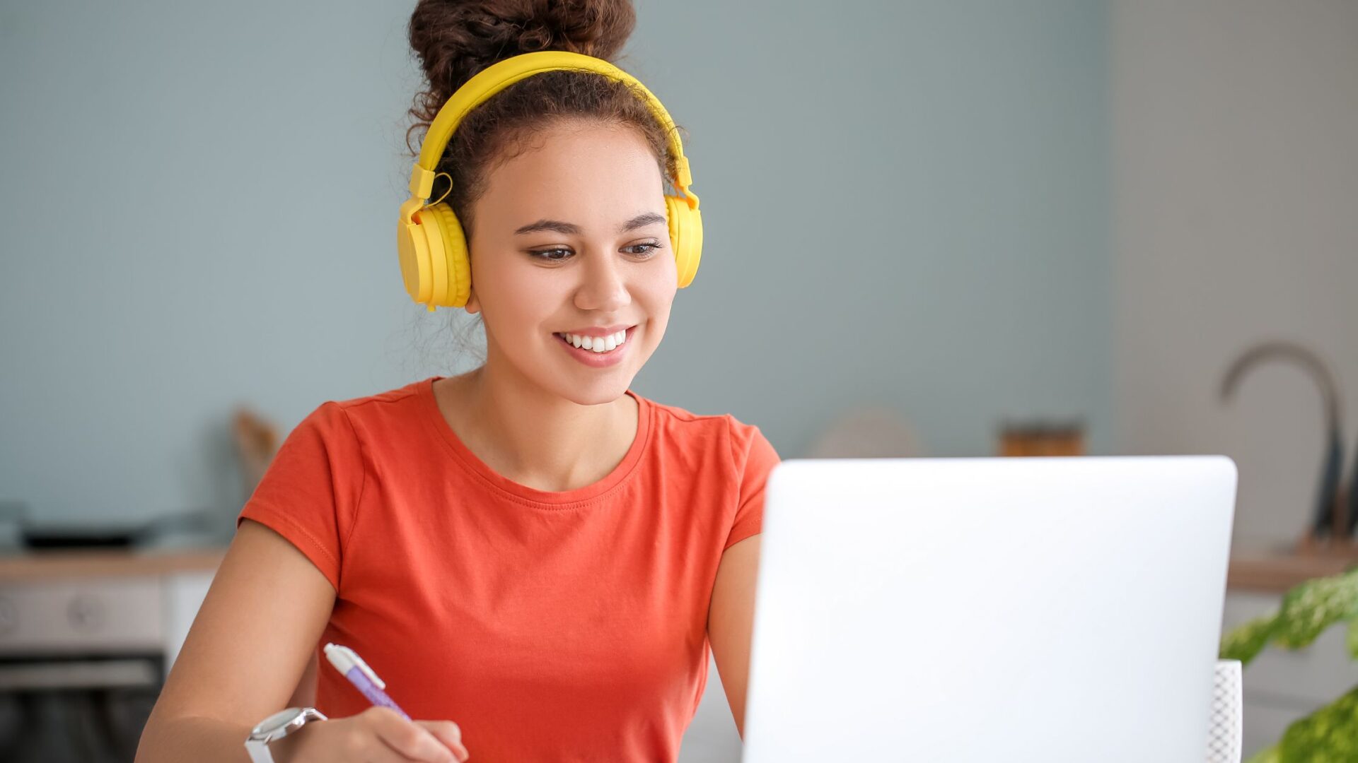 online learning woman with yellow headphones taking an online course