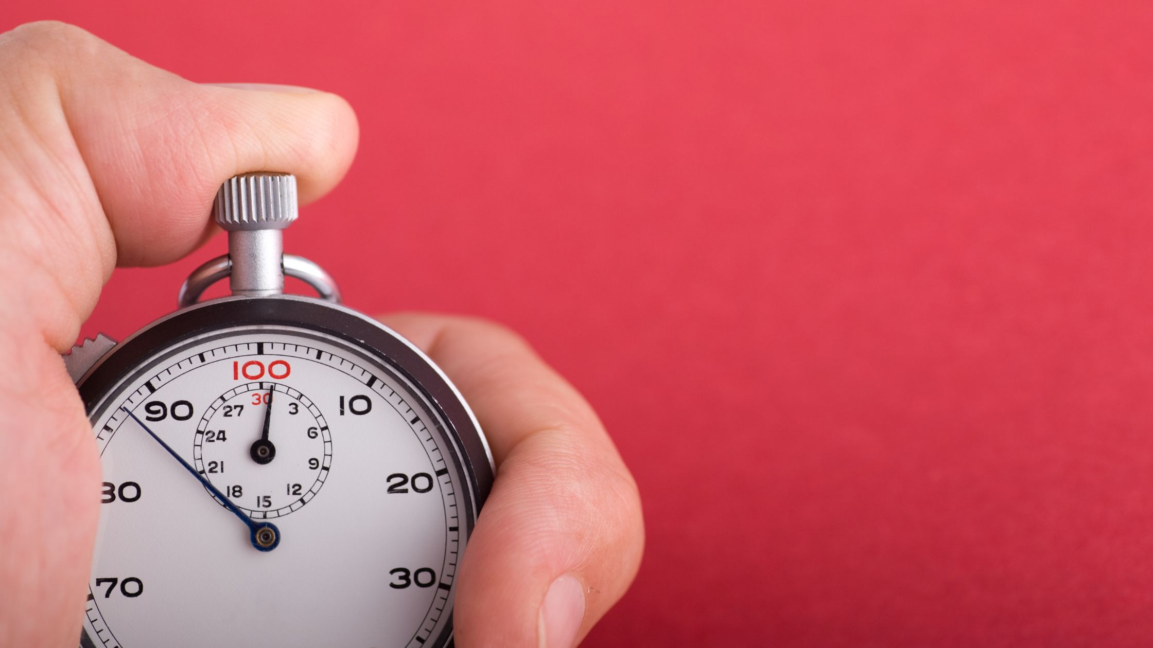 Speed up the sale - Hand holding a stopwatch on red