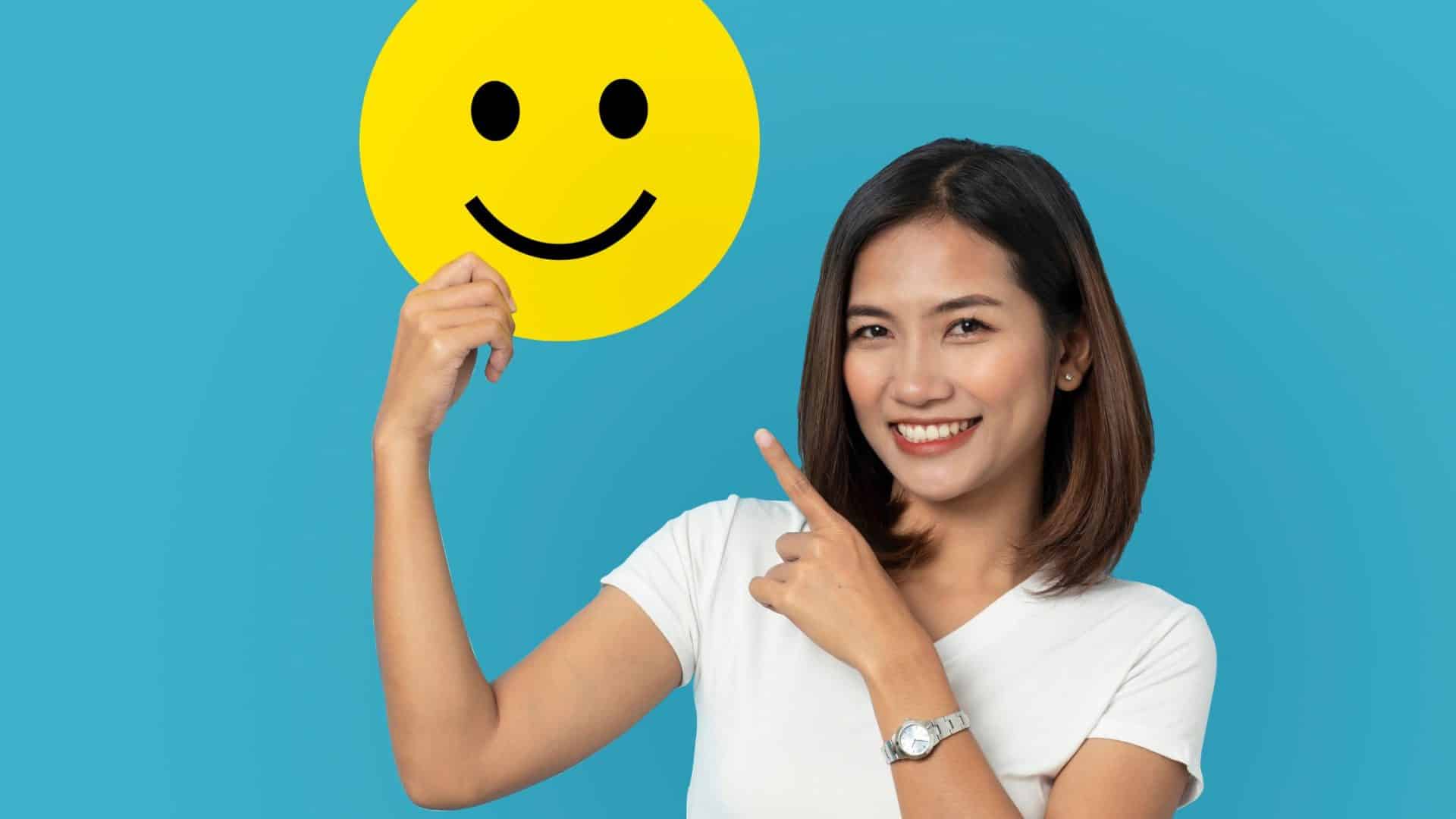 Why Customers Leave Big Companies for Small Business (And the 4-Metric - woman holding a smiley face and pointing at it