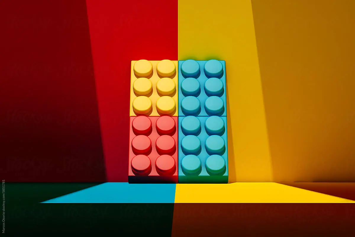 Front view of a Multicolored plastic block leaning on a colorful wall