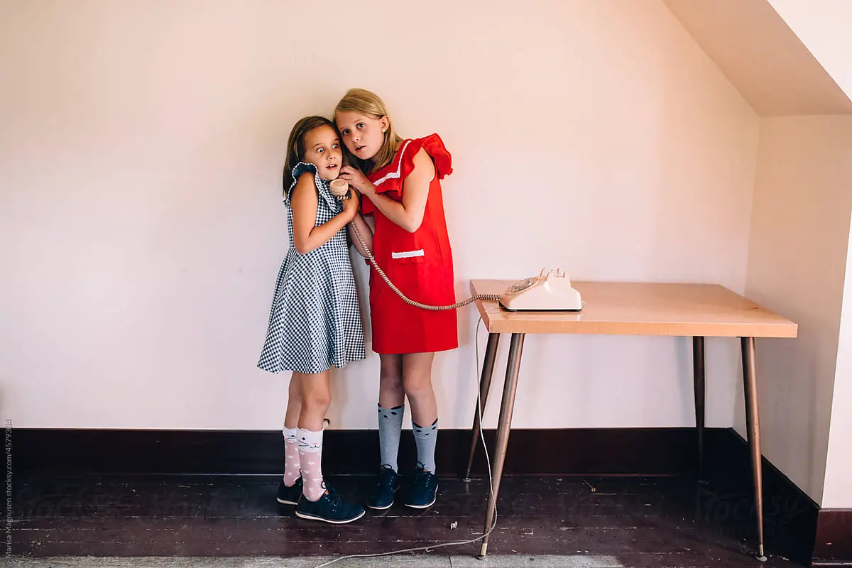 two girls listening on the phone - brand24 social listening