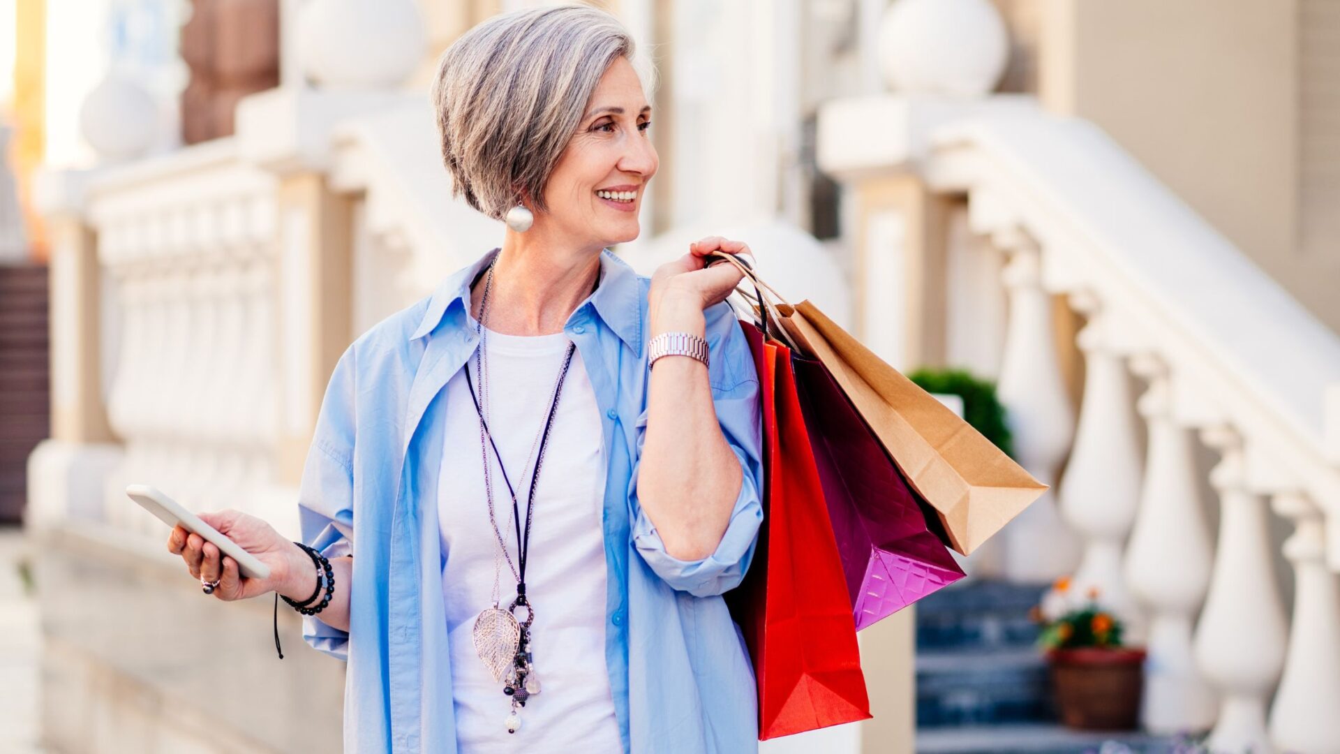 foot traffic - Side view of excited young woman with senior dad holding shopping bags and observing store showcase while choosing Christmas presents together in winter evening in city