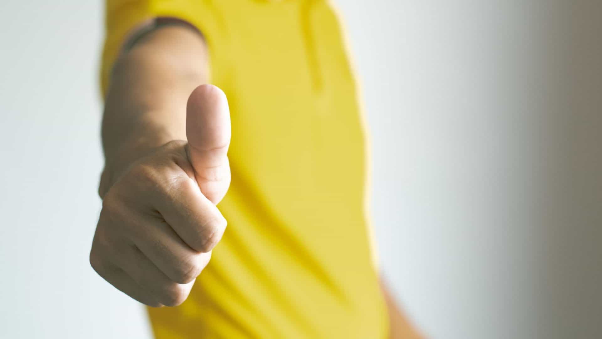 guarantee examples for small business - a man in a yellow shirt giving a thumbs up