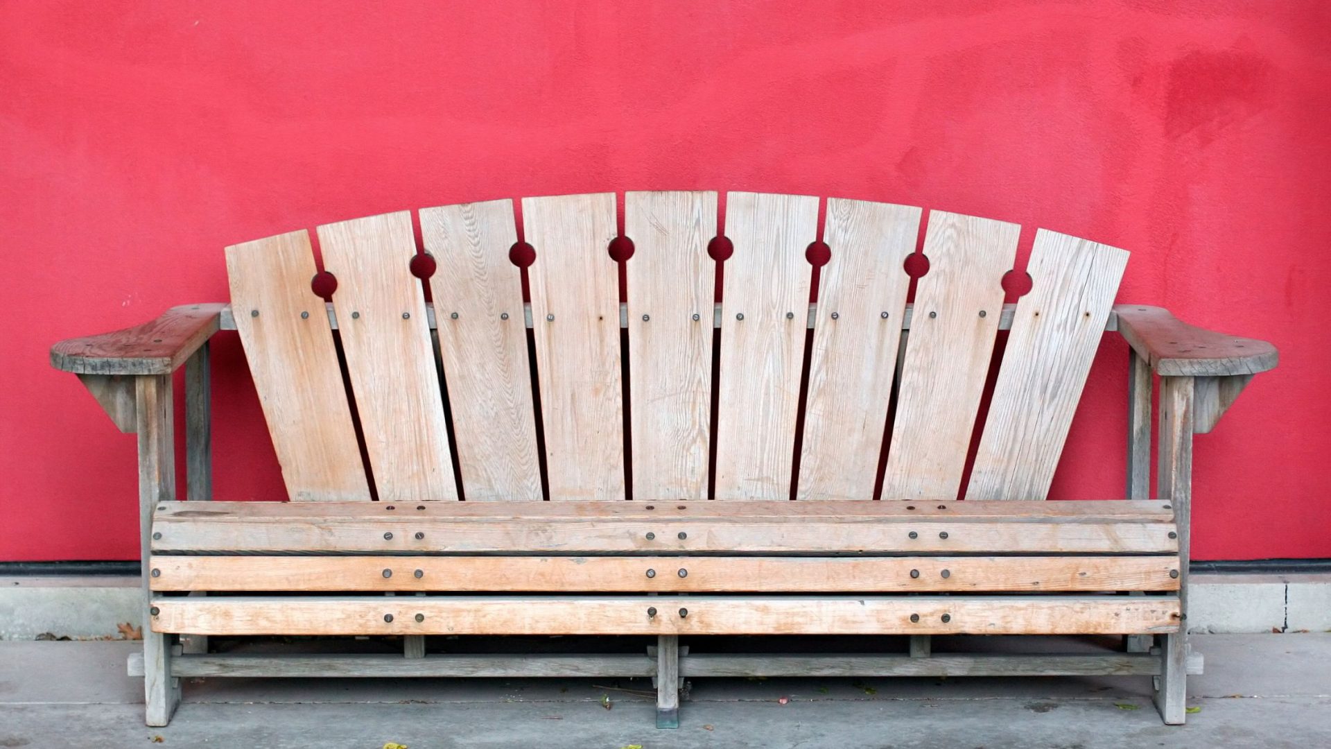 how to benchmark your small business Wooden bench against a red wall