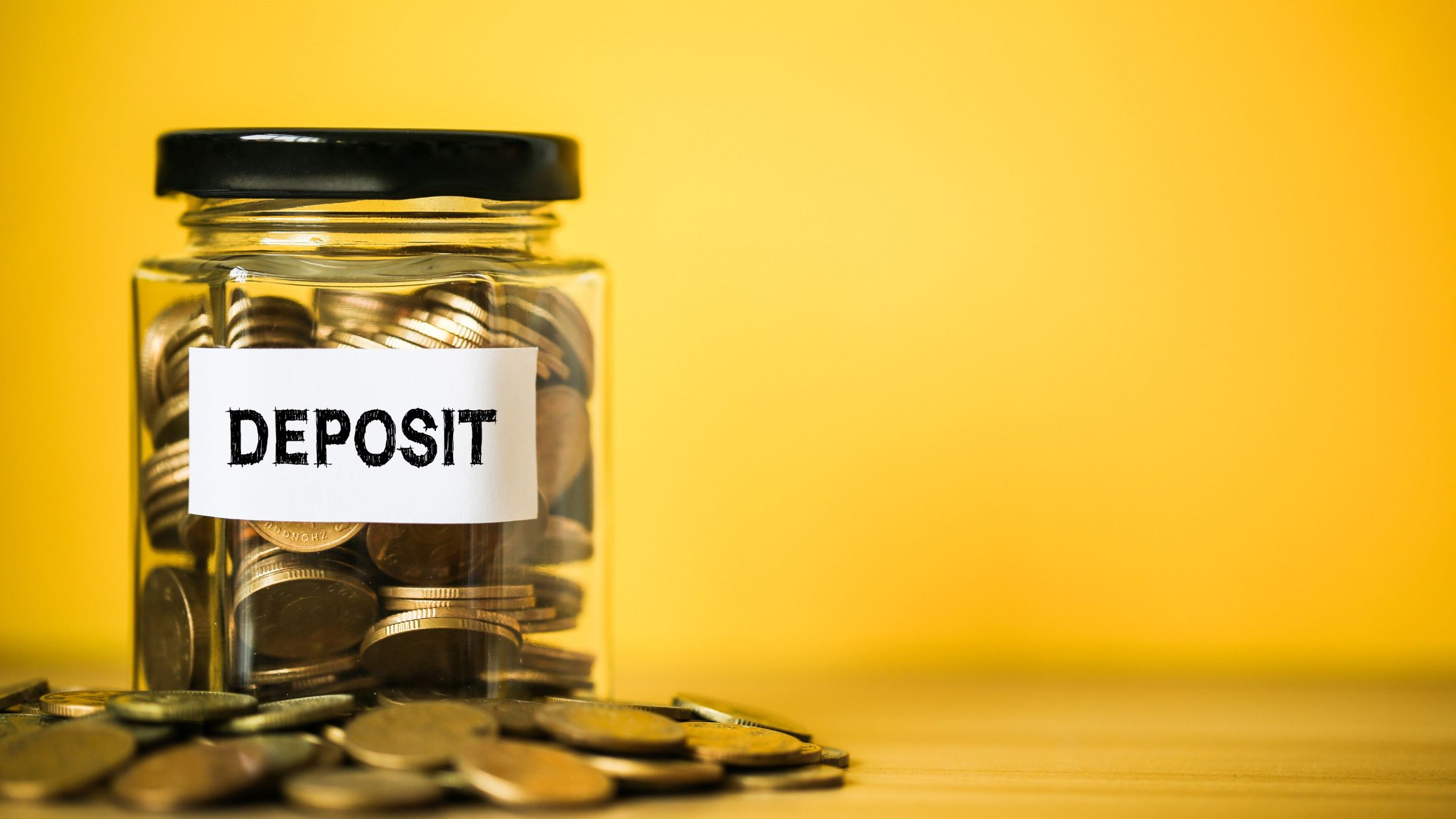 how to require a deposit from clients 1 Glass jar filled with coins.