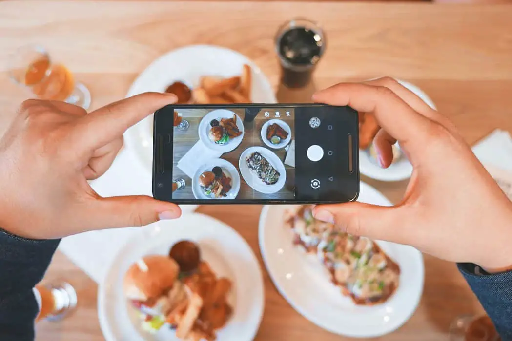 person taking picture of the foods for video marketing