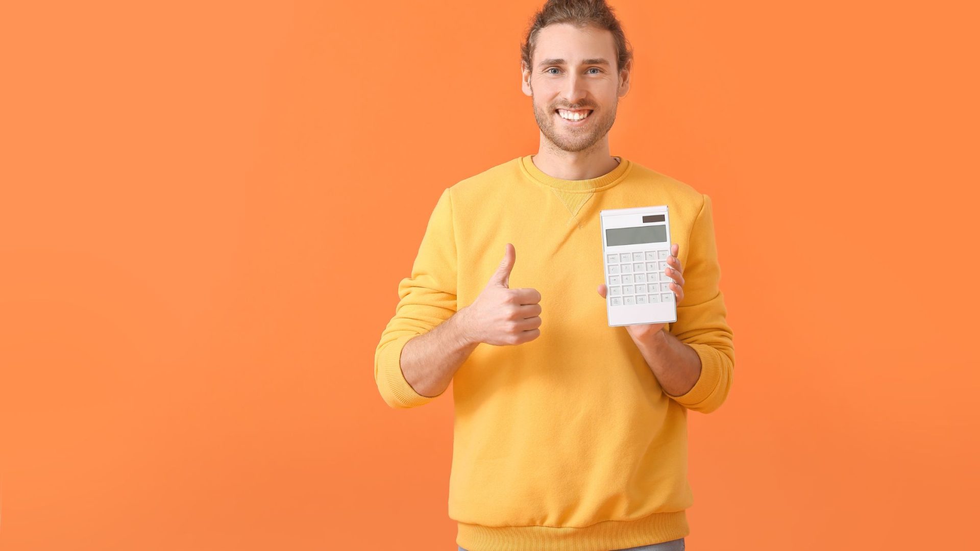 A man with yellow sweater holding a calculator with thumbs up on orange background. marketing audit for small business