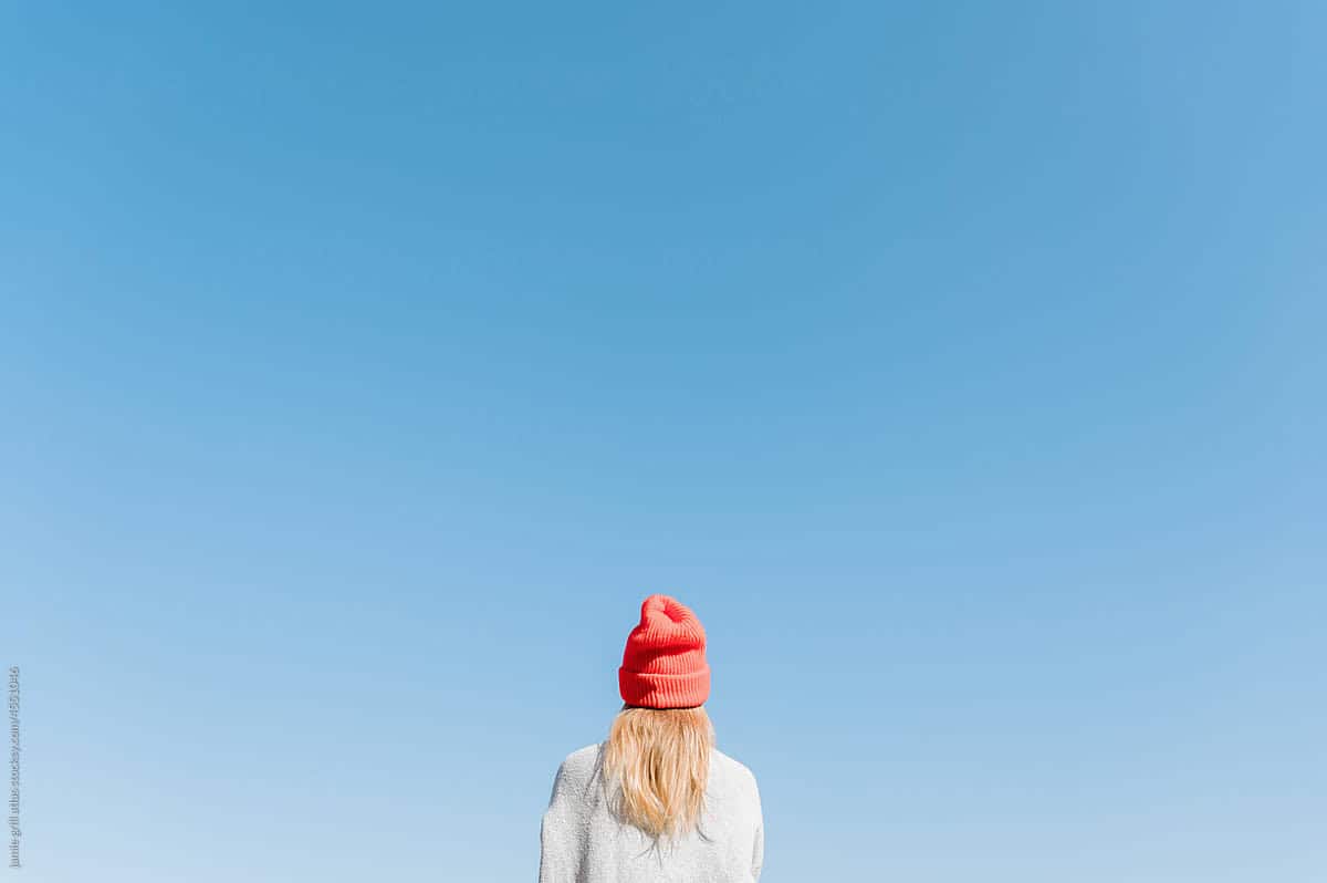 woman looking out towards a wide expanse of optimistic clear blue sky - Marketing mindset