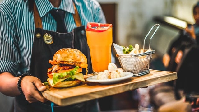 waiter presenting plate to customer