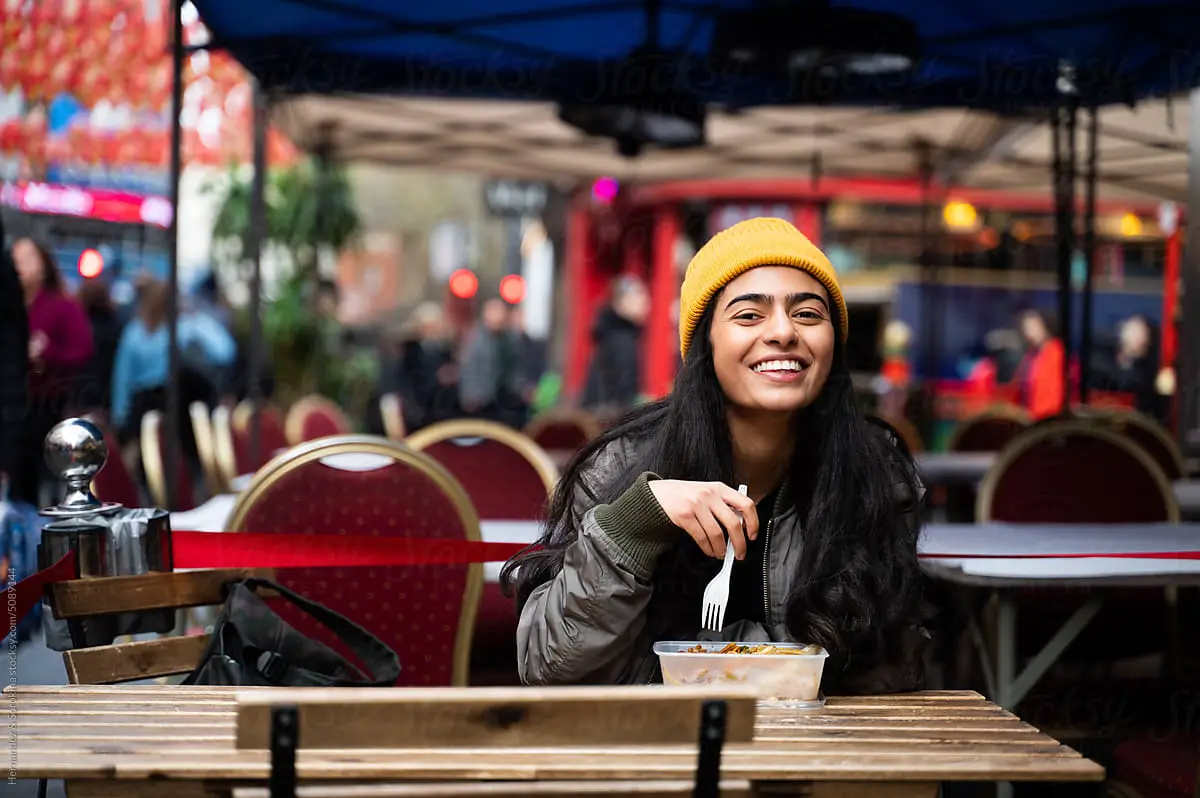 Woman enjoying fast food at restaurant terrace. - persona generator