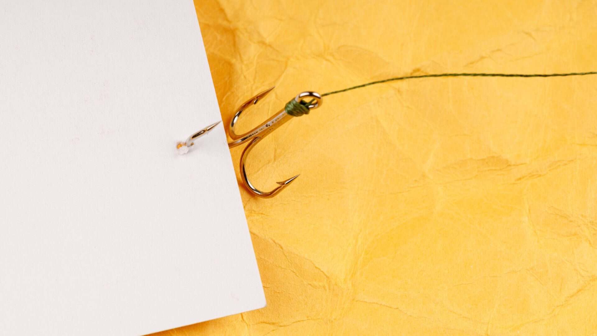 pull marketing strategies for small business - fishing hook pulling in paper on yellow background