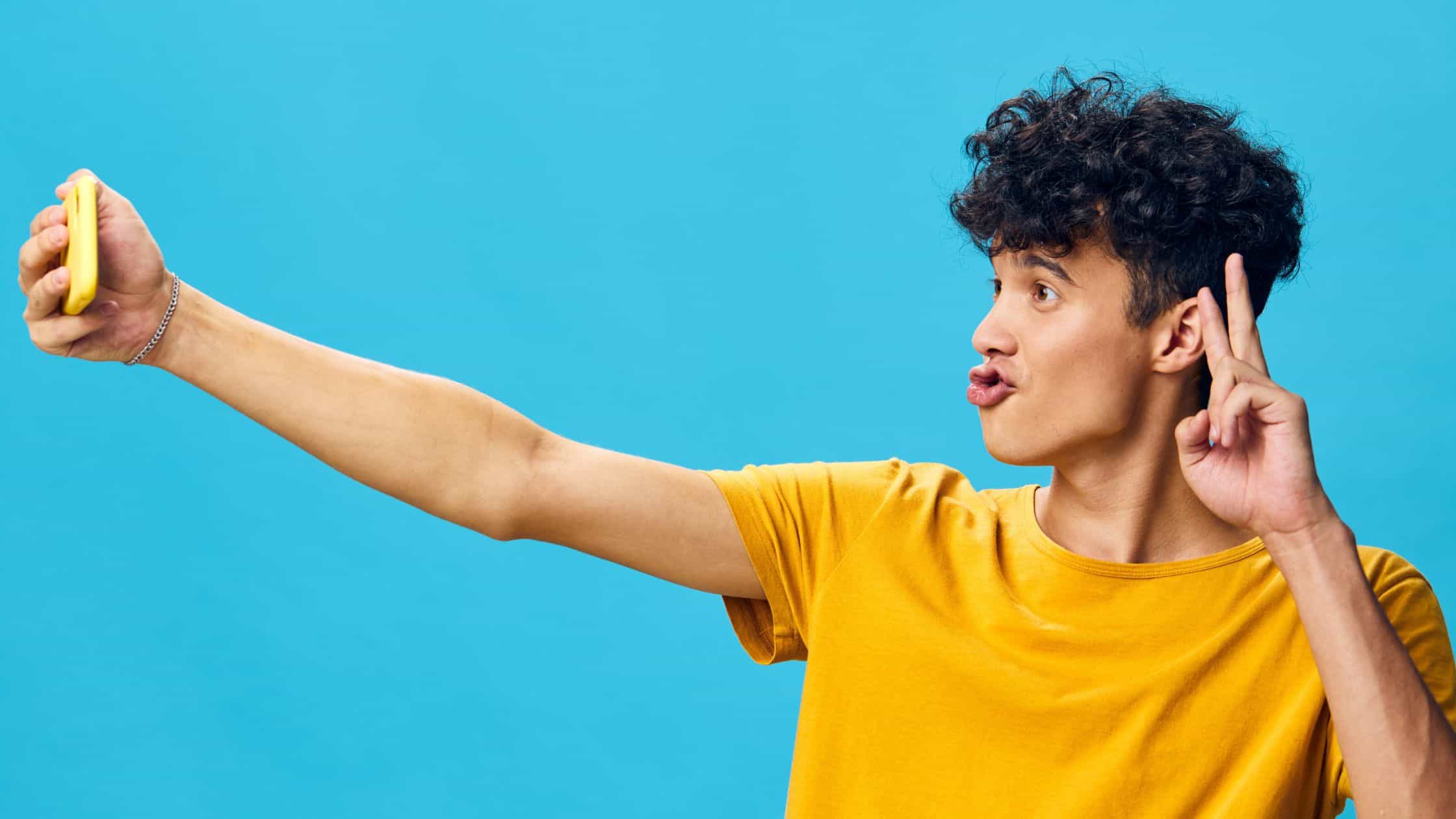 best social media channels for small business - man in yellow shirt taking selfie