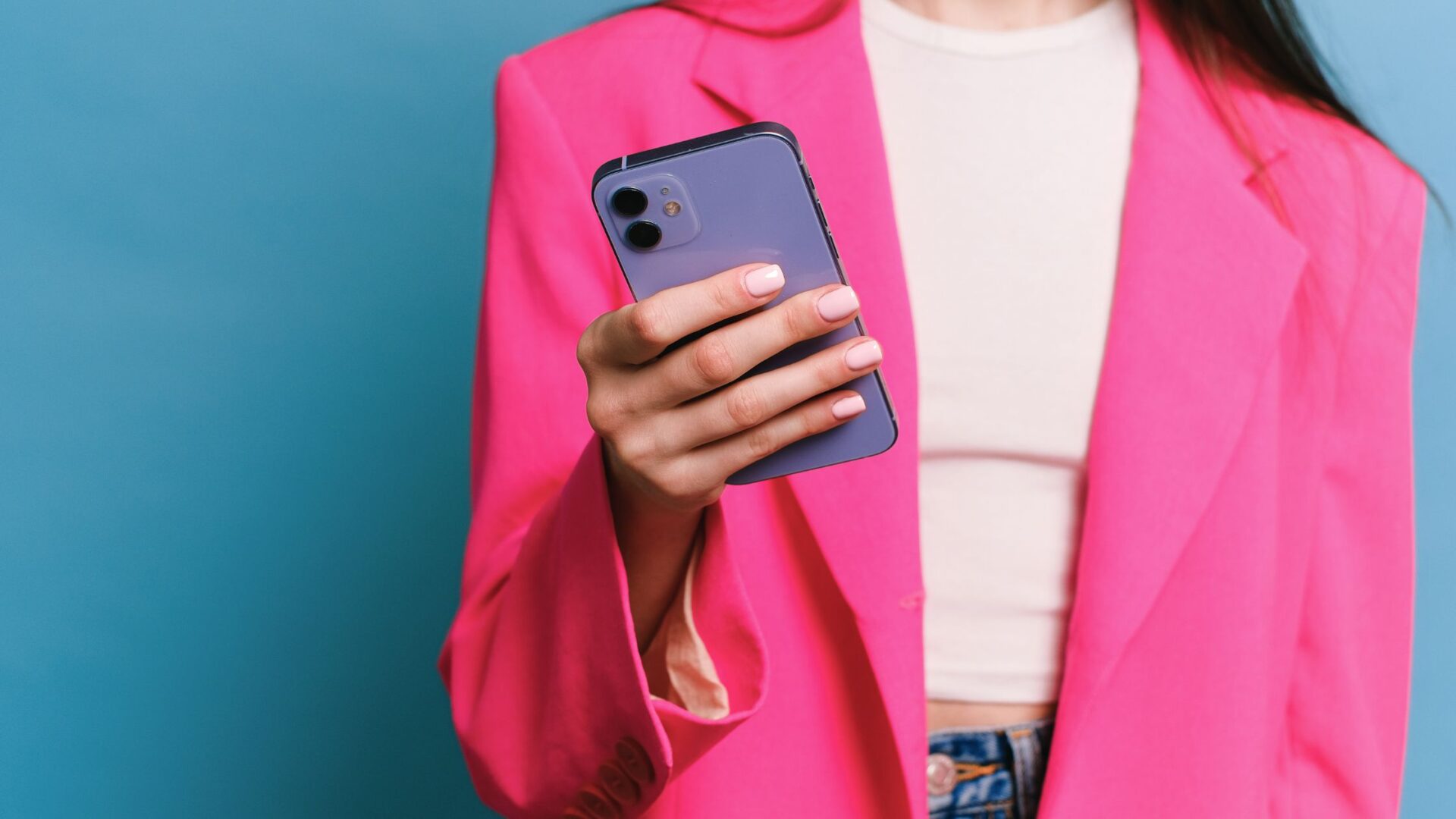 woman in pink blazer holding cell phone looking at google ads