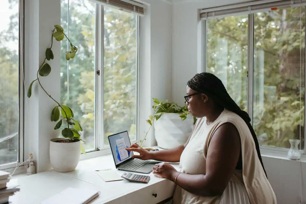 a woman sitting at a table with a laptop - linkedin marketing for freelancers